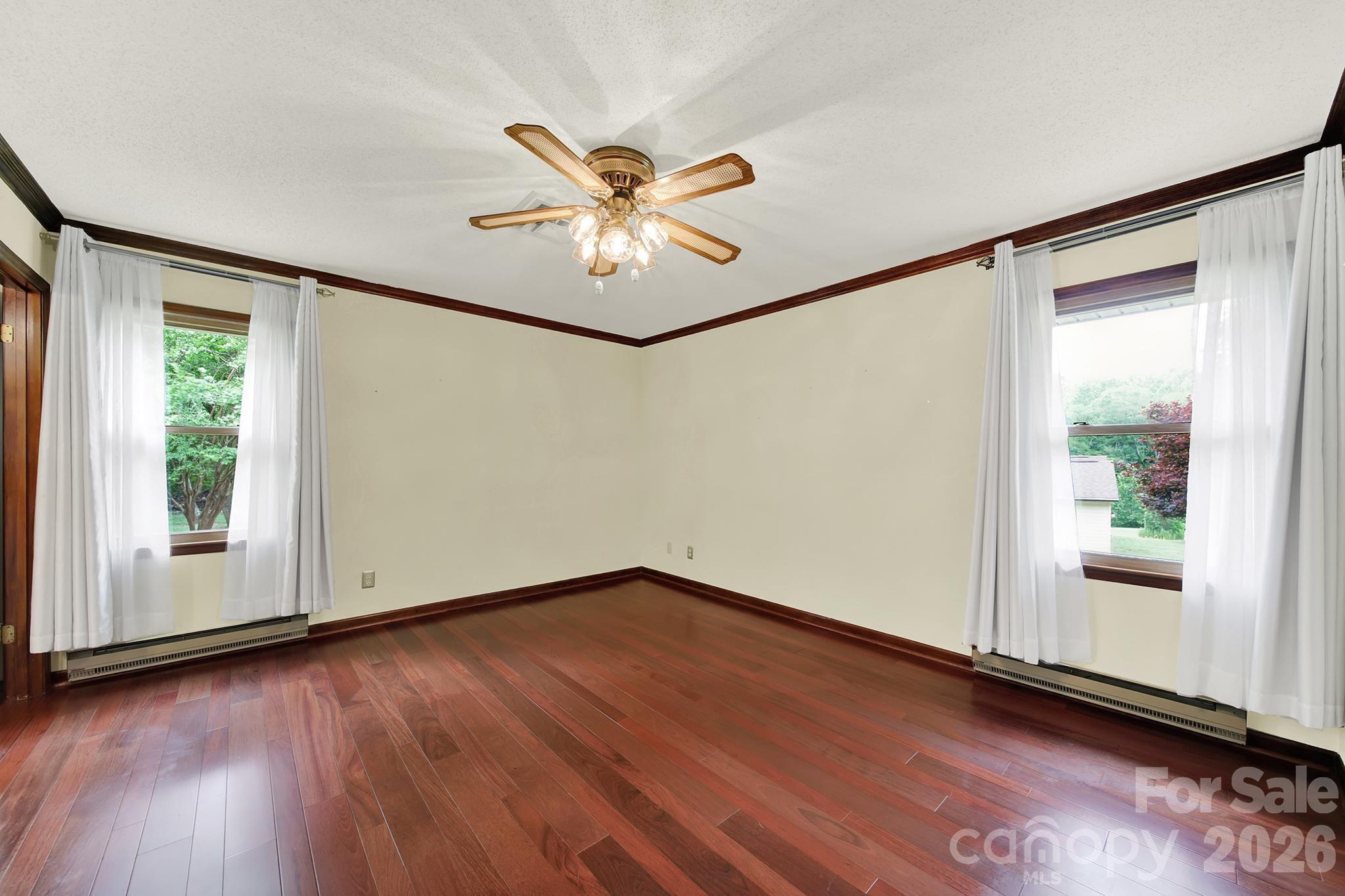 5913 Tom Query Road Charlotte, NC 28213 - Photo 19 of 47 an empty room with wooden floor fan and windows