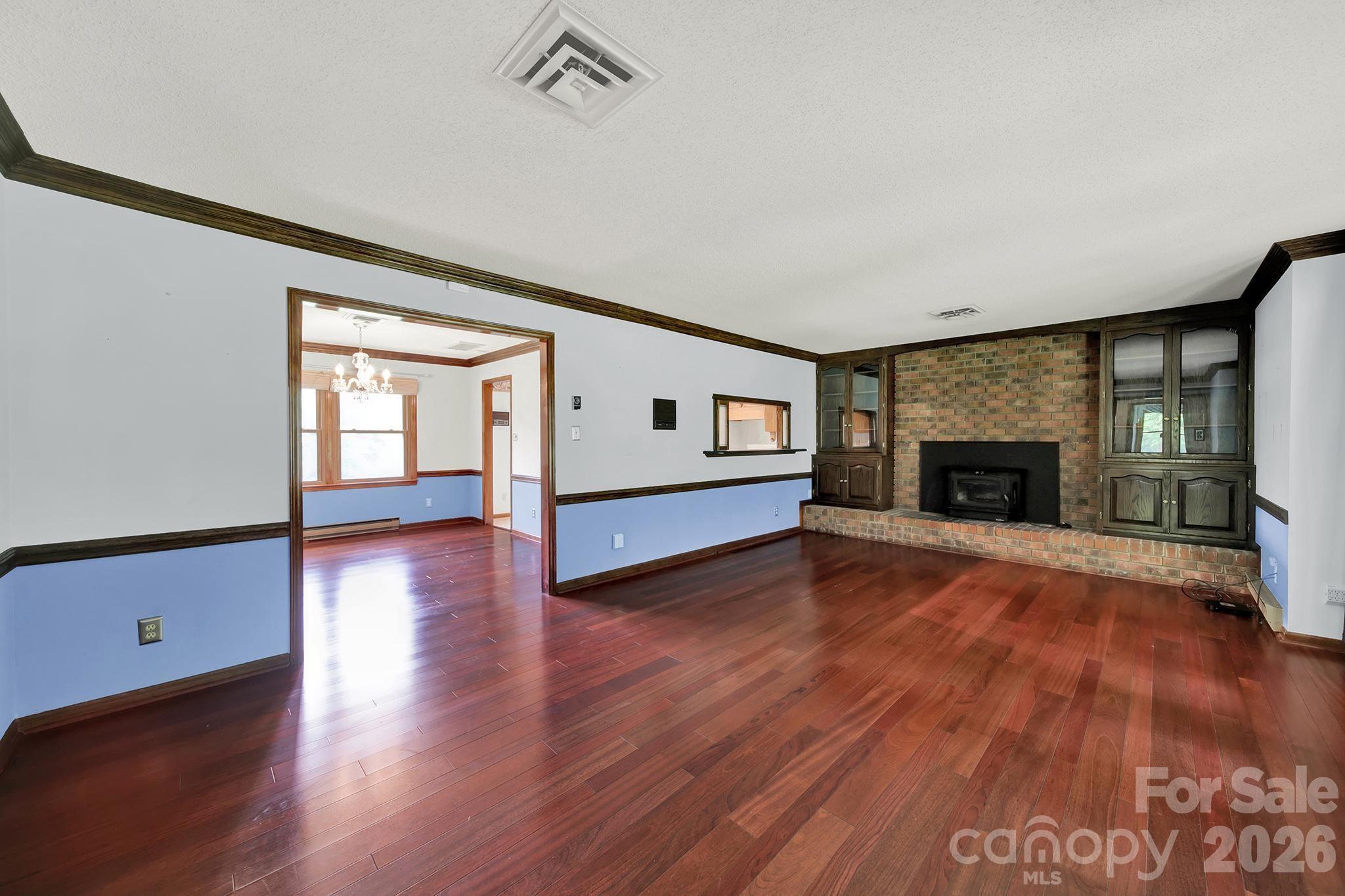 5913 Tom Query Road Charlotte, NC 28213 - Photo 3 of 47 a view of empty room with wooden floor and fireplace