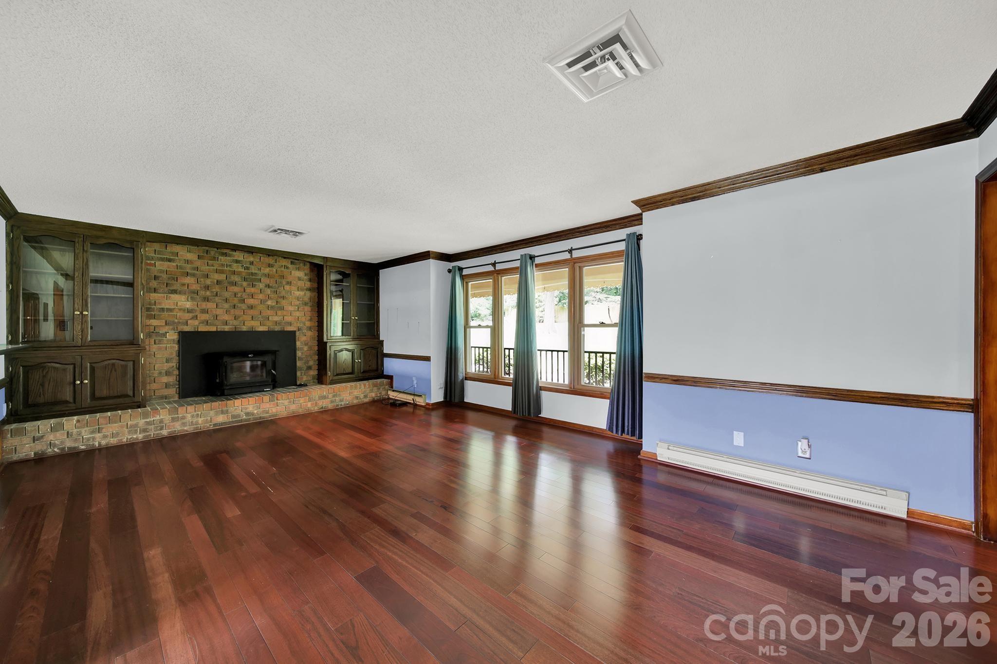 5913 Tom Query Road Charlotte, NC 28213 - Photo 5 of 47 a view of an empty room with wooden floor and a window