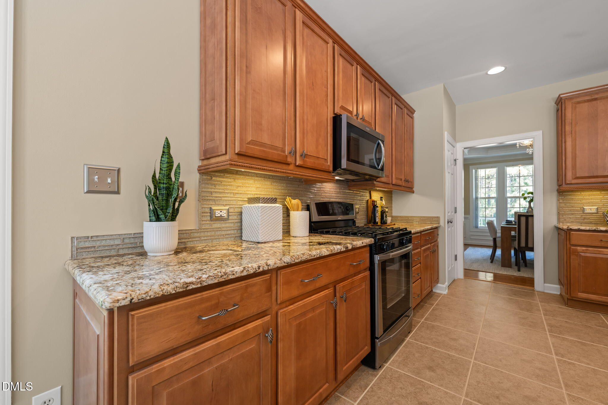 1009 Hidden River Court Raleigh, NC 27614 - Photo 14 of 55 Granite counters with embedded glass backsplash and gas range