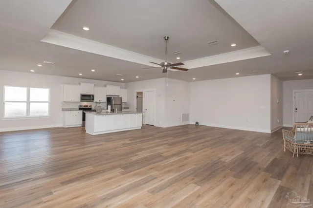 a view of empty room with wooden floor and window
