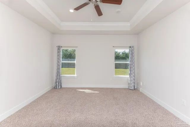 an empty room with a window and a ceiling fan