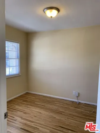 a view of a room with wooden floor and cabinet