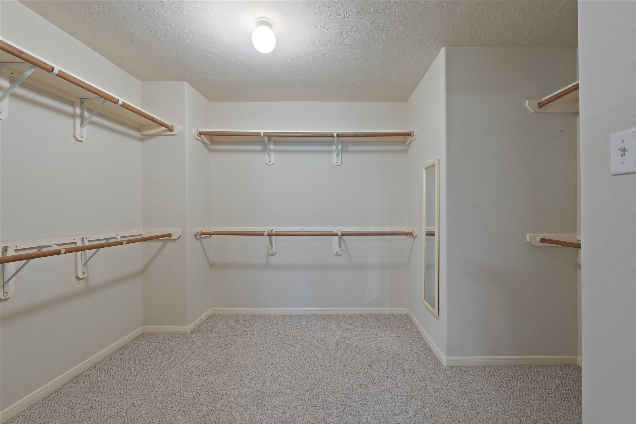 7414 Hollister Spring Houston, TX 77040 - Photo 19 of 26 Spacious primary closet with ample shelving and hanging space for organized storage.