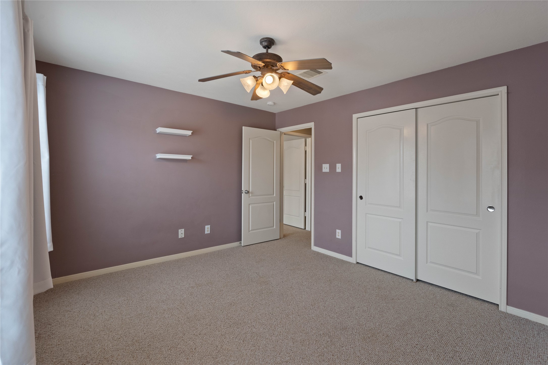 7414 Hollister Spring Houston, TX 77040 - Photo 23 of 26 Spacious and inviting secondary bedroom with ample natural light, cozy carpeting, and a stylish ceiling fan.
