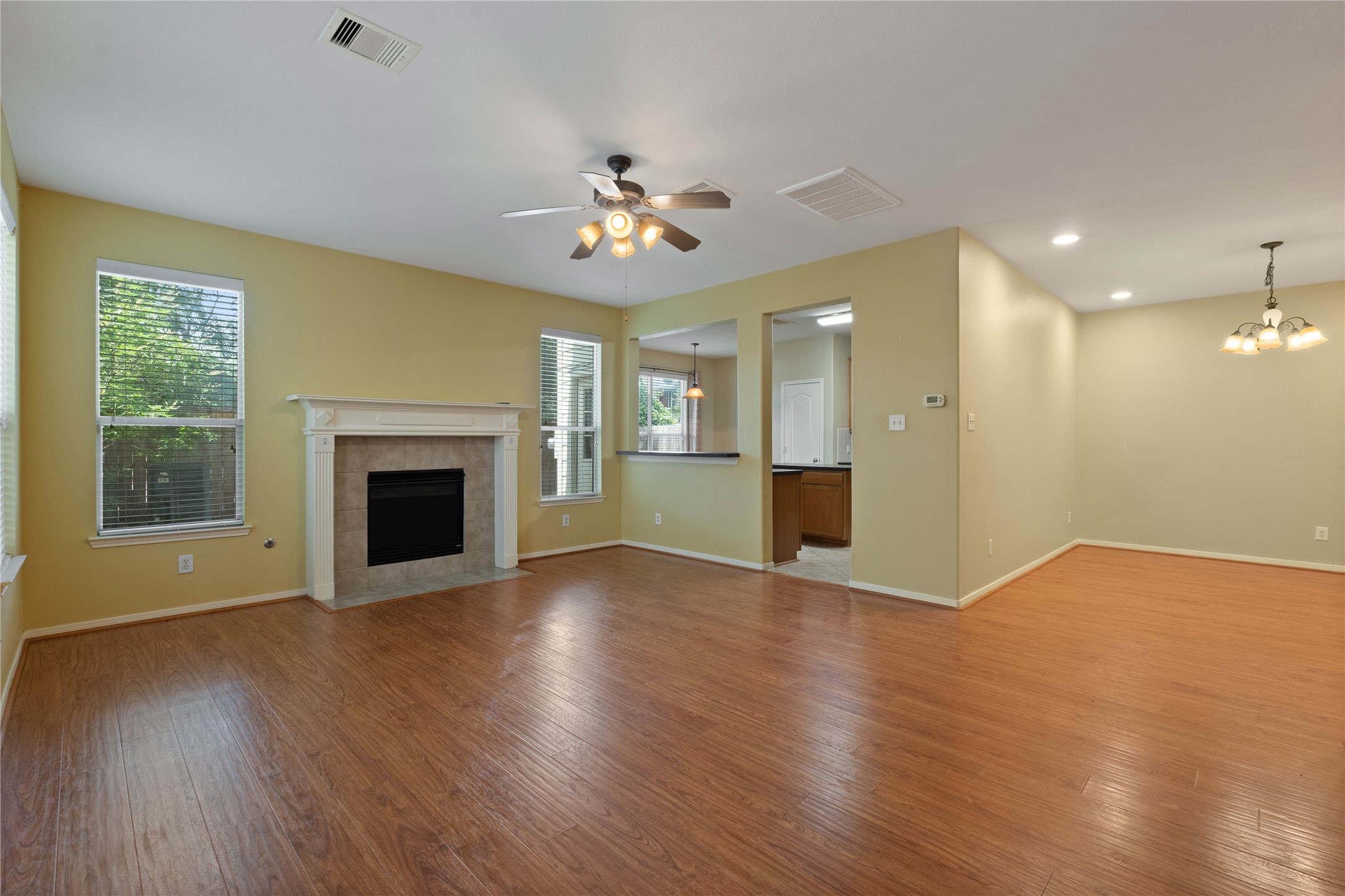 7414 Hollister Spring Houston, TX 77040 - Photo 3 of 26 Open-concept living and dining area with fireplace, and natural light. Kitchen with pass-through window and ample cabinet space.