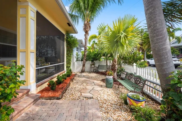 a living room with patio furniture and a potted plant