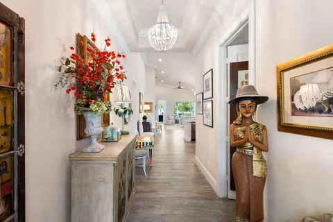 a living room with furniture a flat screen tv and a chandelier