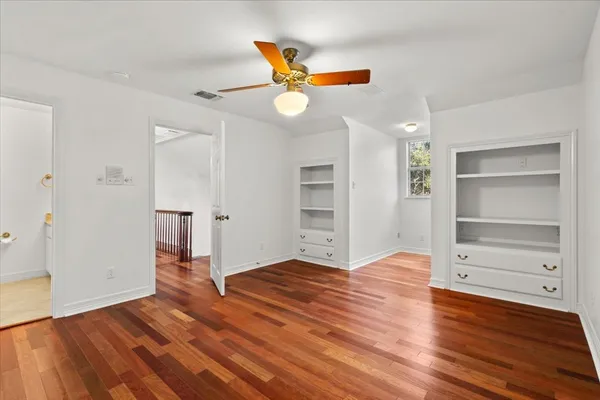 an empty room with wooden floor and window
