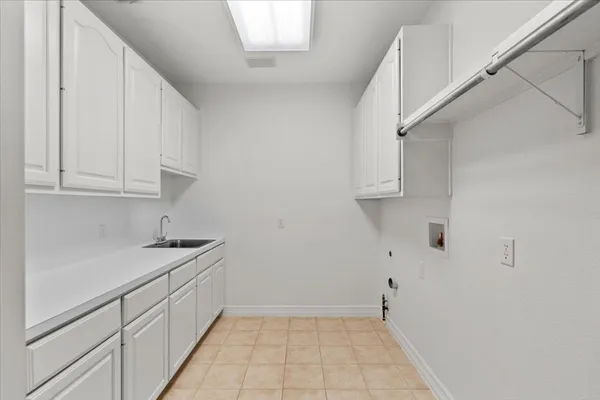 a kitchen with white cabinets and sink