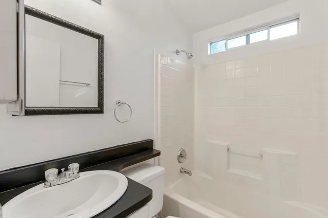a bathroom with a sink vanity tub and a mirror