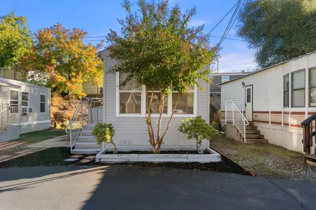 a view of a white house with a table and chairs