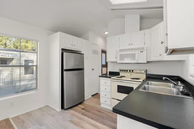 a kitchen with a refrigerator sink and cabinets
