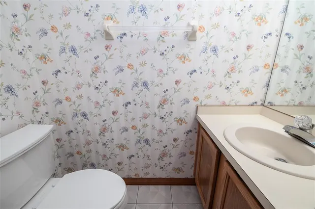 a bathroom with a granite countertop toilet and a sink