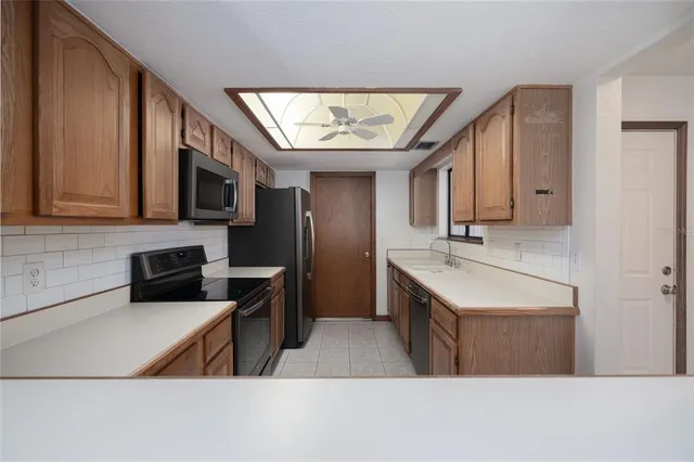 a kitchen with stainless steel appliances a stove a sink a microwave and cabinets