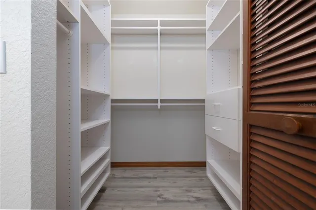 a view of walk in closet with empty racks