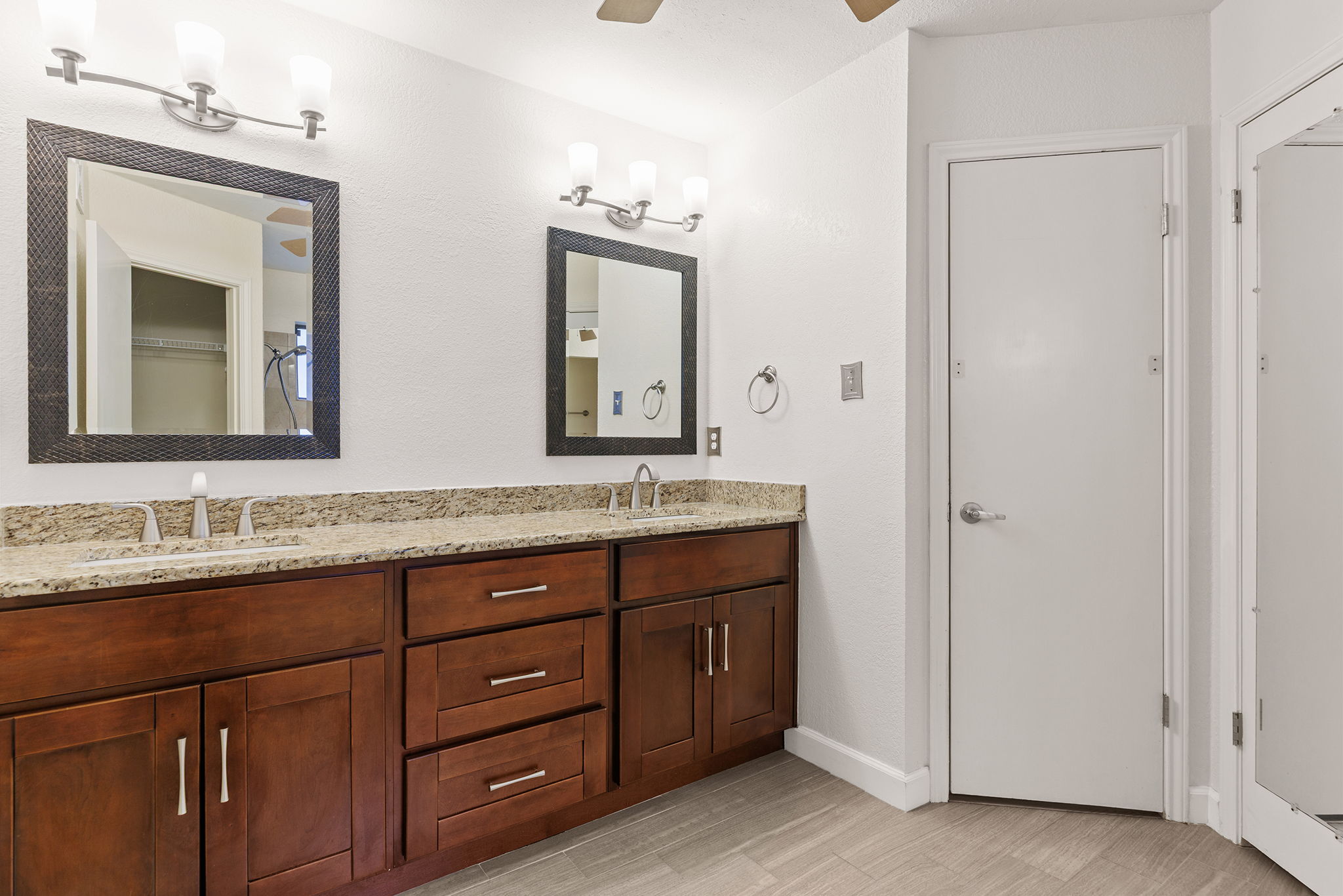 2409 Water Well Lane Austin, TX 78728 - Photo 15 of 22 Double vanity featuring brown cabinetry, light speckled countertops, and undermount sinks
