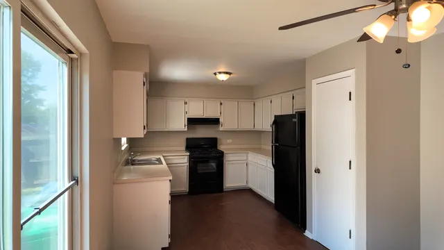 a kitchen with cabinets appliances a sink and a window