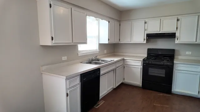 a kitchen with a refrigerator and white cabinets