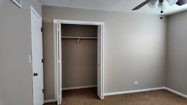 a view of a chandelier fan and closet area