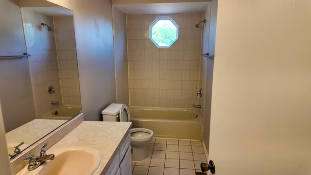 an empty room with a window and a fan