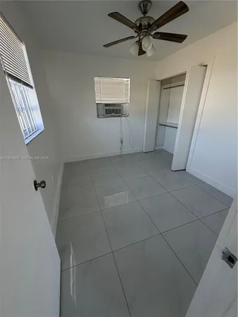 an empty room with windows and closet