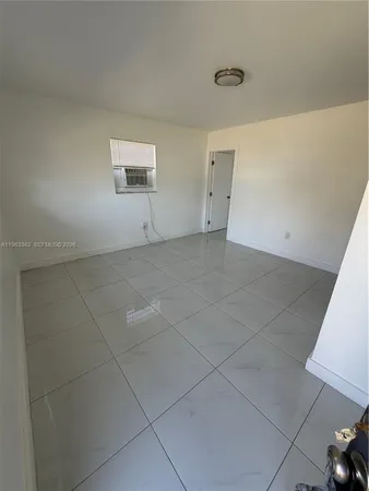 a view of an empty room and chandelier fan