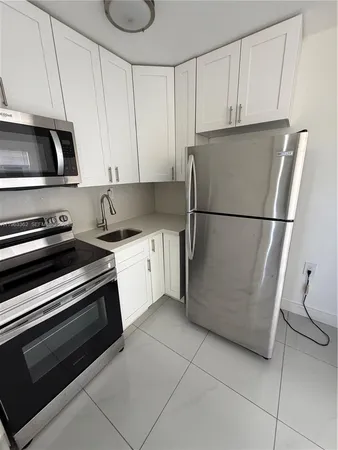 a kitchen with a refrigerator and a stove