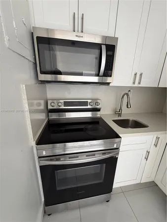 a stove top oven sitting inside of a kitchen