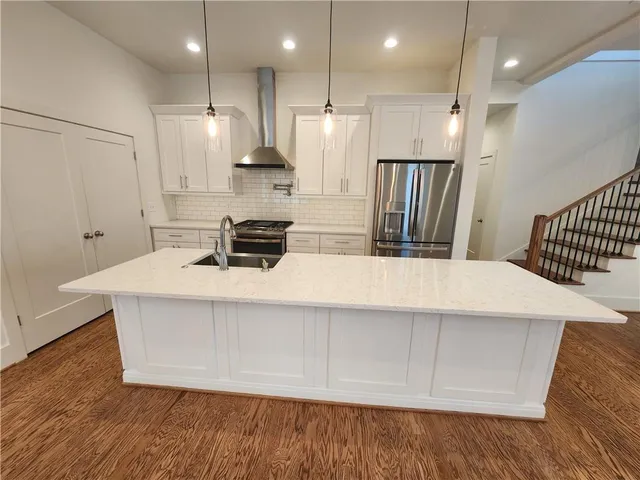 a kitchen with kitchen island a stove a refrigerator and a sink