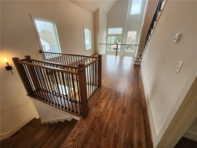 a view of a hallway with wooden floor and stairs