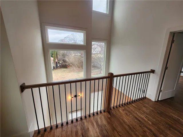 a view of a hallway with wooden floor and a window