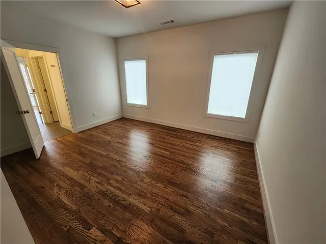 an empty room with wooden floor and a window