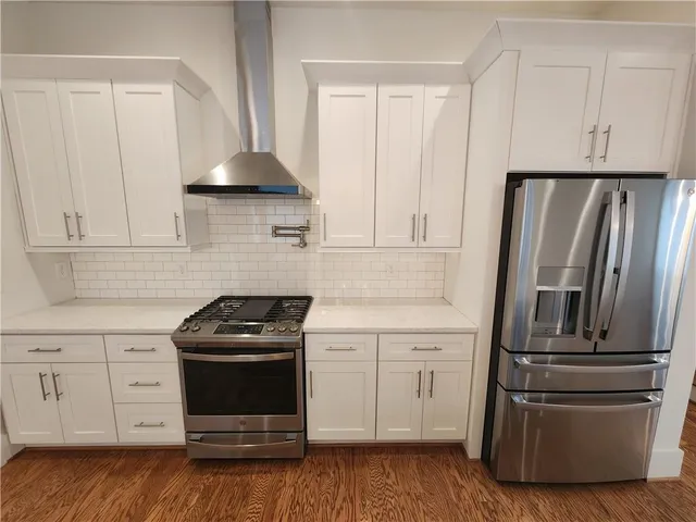 a kitchen with white cabinets and stainless steel appliances