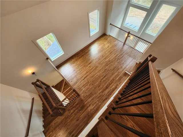a view of an empty room with wooden floor and a floor to ceiling window