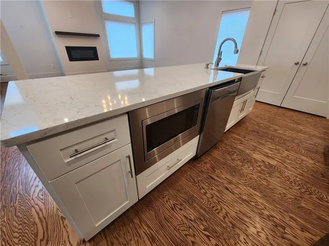 a kitchen with stainless steel appliances a stove a microwave and a hard wood floors