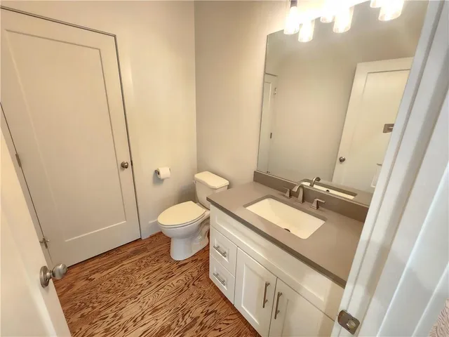 a bathroom with a sink a toilet a mirror and shower