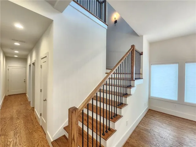 a view of staircase with wooden floor and white walls