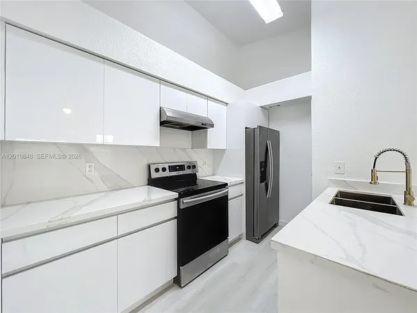 a kitchen with stainless steel appliances a sink stove and refrigerator