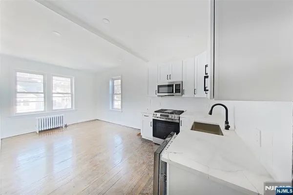 a kitchen with stainless steel appliances a sink a stove a refrigerator a window