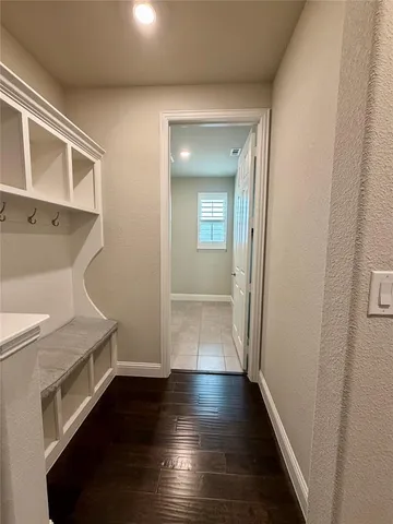 a view of a hallway with wooden floor and staircase