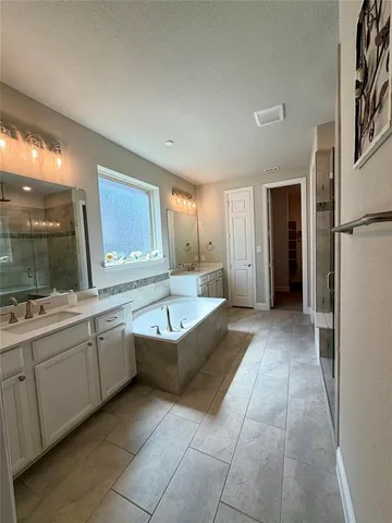 a large bathroom with a large tub and sink