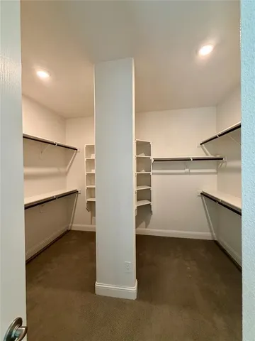 a view of walk in closet with empty racks