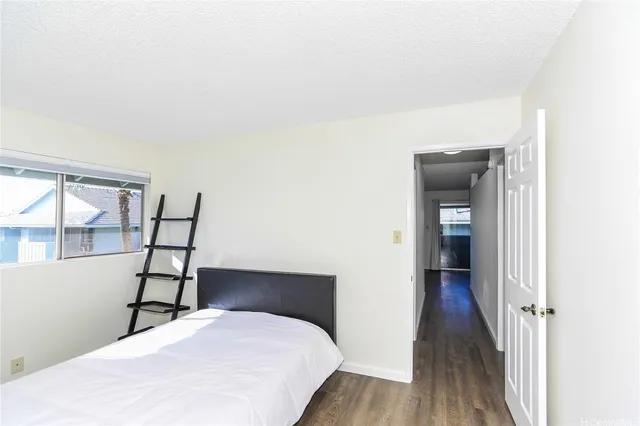 a bedroom with a bed and a wooden floor