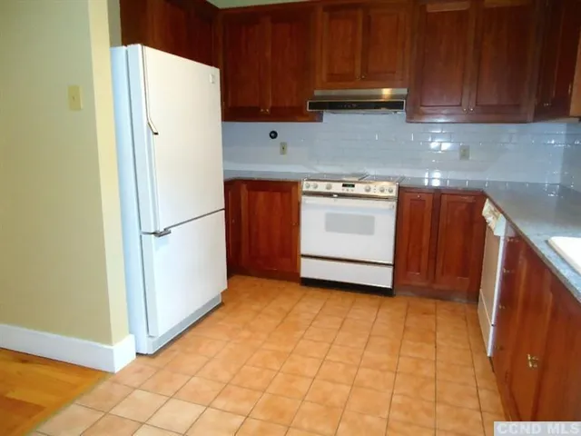 a kitchen with a white stove top oven and refrigerator