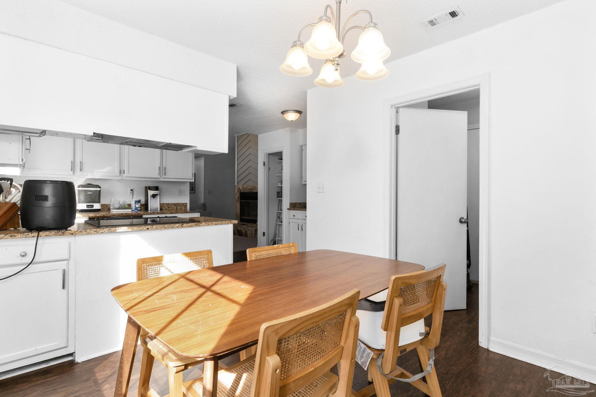 121 Claire Drive Crestview, FL 32536 - Photo 17 of 45 a kitchen with stainless steel appliances kitchen island granite countertop a refrigerator a stove a sink dishwasher with a dining table and chairs