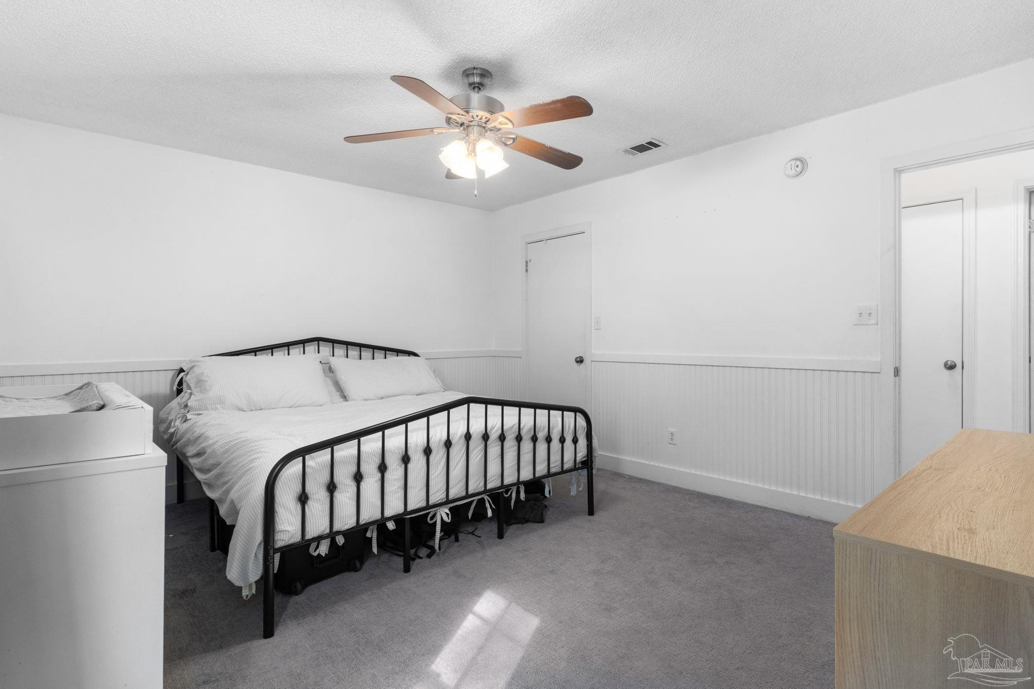 121 Claire Drive Crestview, FL 32536 - Photo 29 of 45 a spacious bedroom with a bed and a chandelier