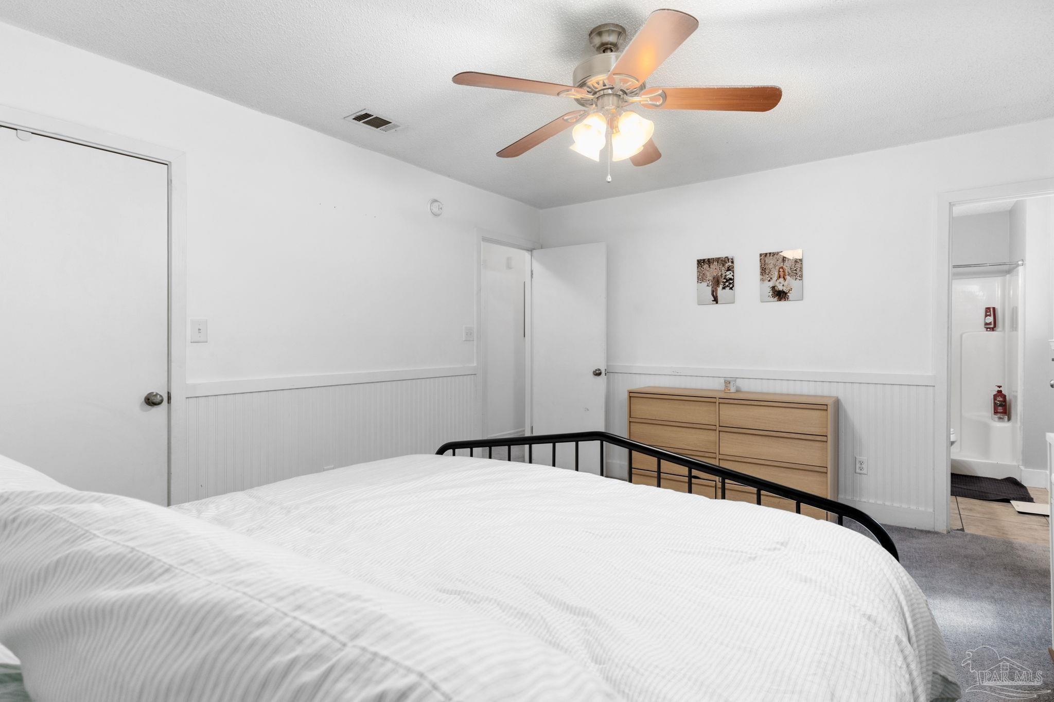 121 Claire Drive Crestview, FL 32536 - Photo 30 of 45 a bedroom with a large bed and a chandelier