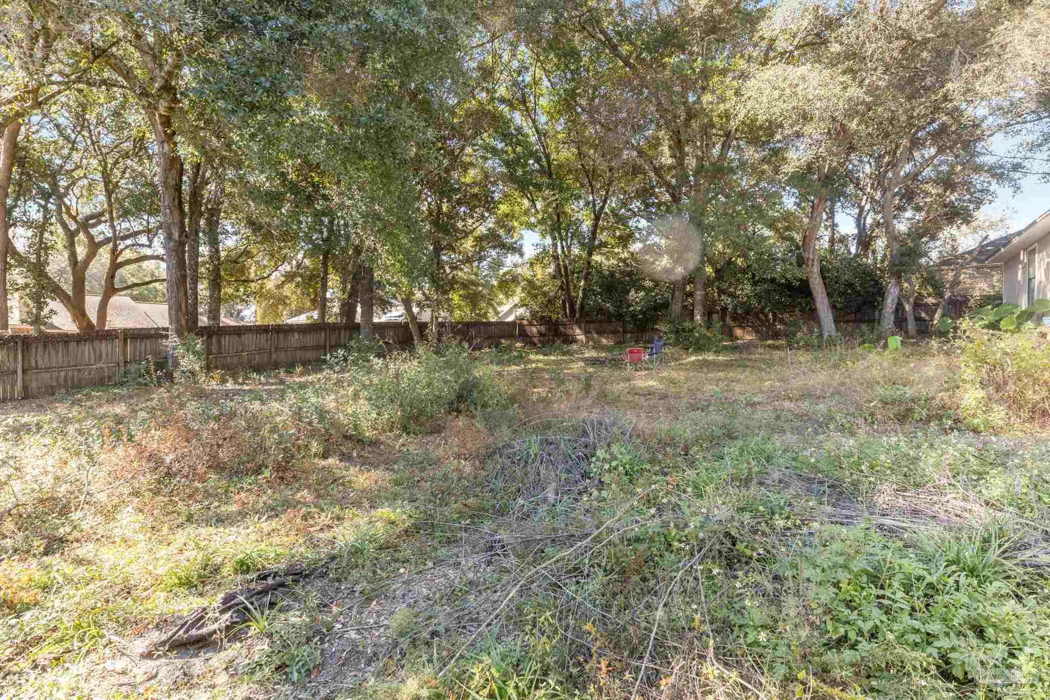 121 Claire Drive Crestview, FL 32536 - Photo 36 of 45 a backyard of a house with lots of plants and large tree