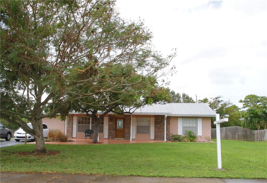 1153 Northwest Spruce Ridge Drive Stuart, FL 34994 - Photo 1 of 22 front view of a house with a yard